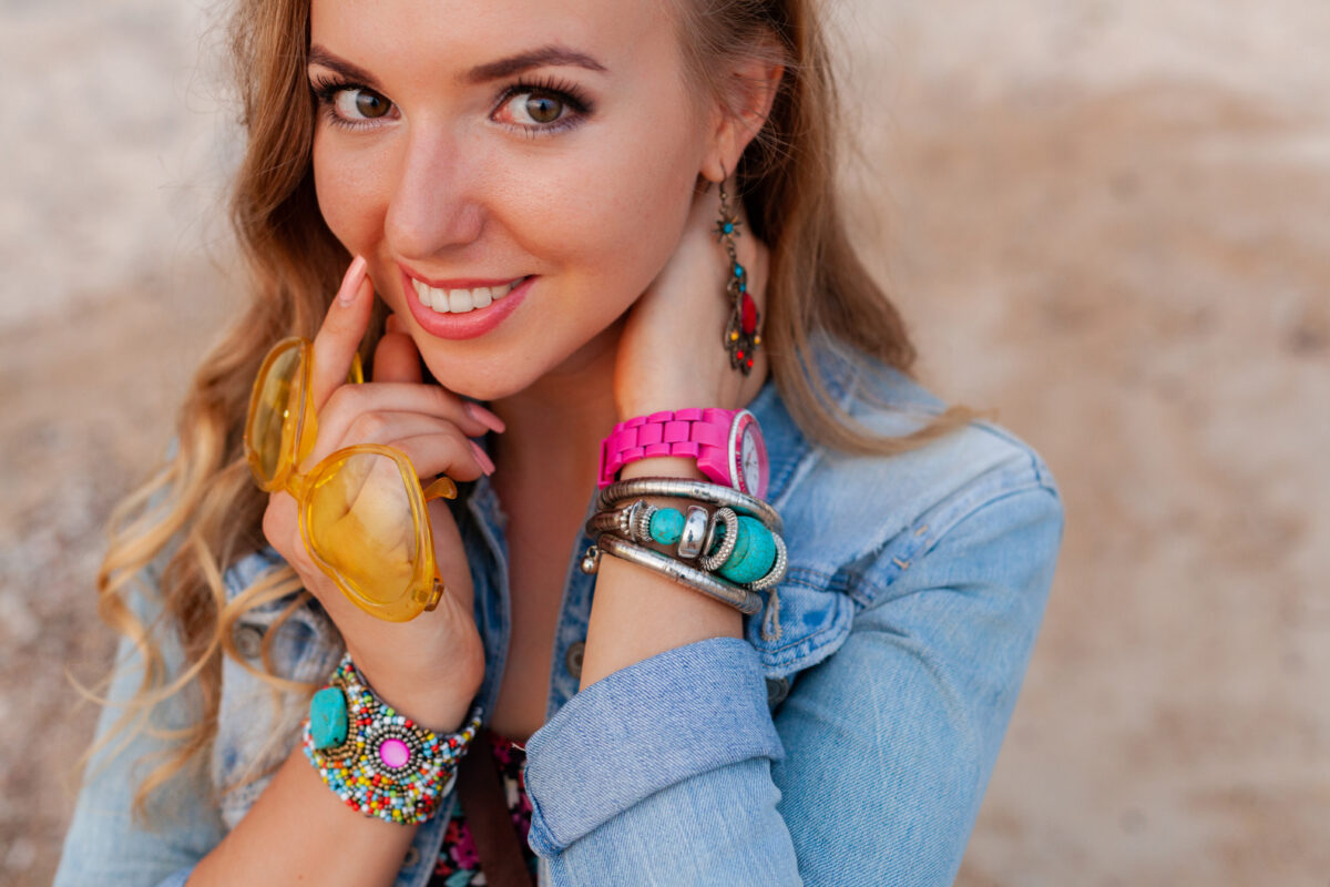 stylish woman in vacation on beach in colorful yellow sunglasess smiling happy accessories jewelry
